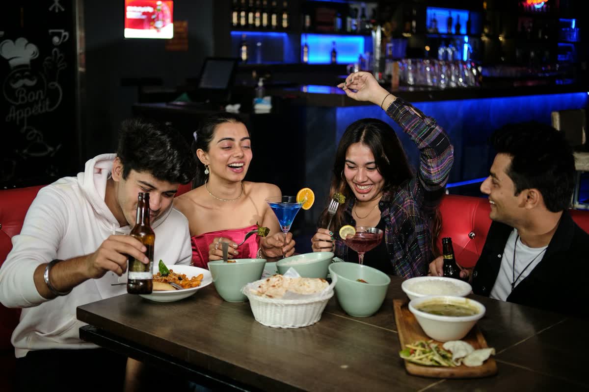 Amigos rindo e comendo juntos à mesa de um restaurante